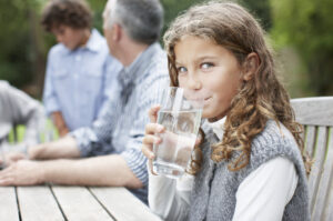 Girl drinking water at picnic table